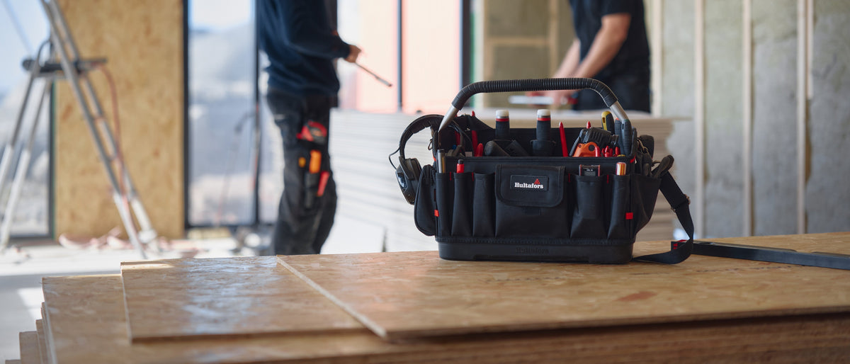 Open ergonomic tool bag from Hultafors filled with tools at a worksite.